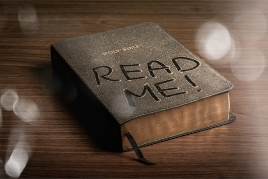 Holy Bible  book with read me letters on a wooden background
