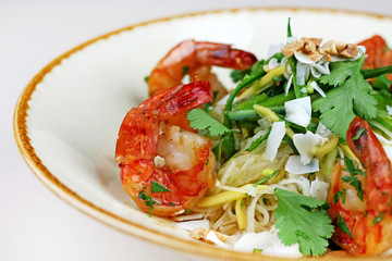 Shrimp and rice noodle salad with coconut chips, peanuts and coriander.