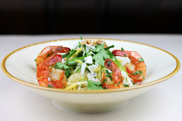 Shrimp and rice noodle salad with coconut chips, peanuts and coriander.