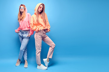Two Young hipster Woman in Stylish neon hoodie, fashion jeans having fun. Funny adorable...