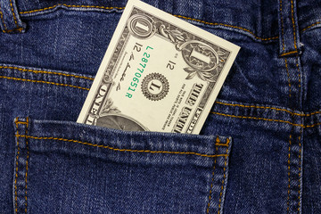 One dollar bill in a pocket of blue jeans