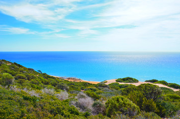 Beautiful seascape in Karpas Peninsula, Turkish Northern Cyprus taken from the adjacent hills surrounded by green trees. The Cypriot coast is a popular summer vacation destination.