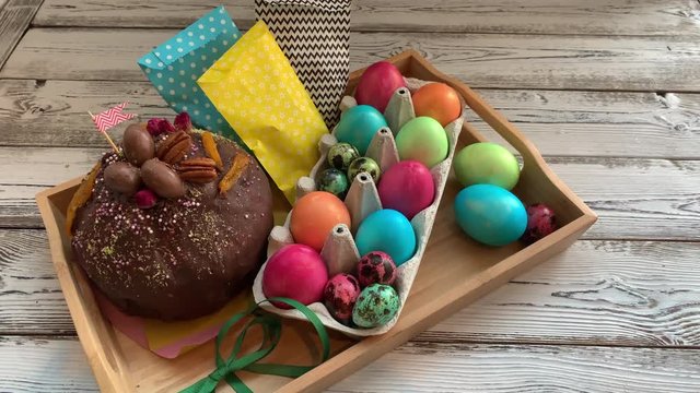 	Easter, sweet table. Homemade chocolate cake in chocolate glaze, with colored quail and chicken eggs.