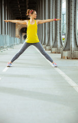sports woman on Pont de Bir-Hakeim bridge in Paris stretching