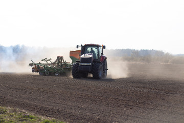 sowing time.tractor trailer rides on the field and sows grain