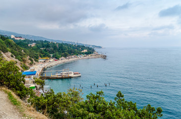 Bay of the sea, a small pier and a narrow strip of beach