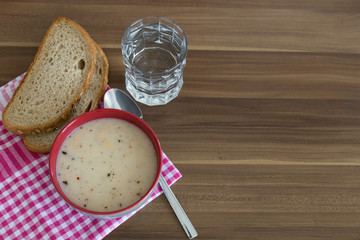 A cup of soup,bread ,date and water service on the wooden table for Ramadan ,thanksgiving. A little meal for diet. 