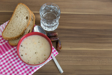 A cup of soup,bread ,date and water service on the wooden table for Ramadan ,thanksgiving. A little meal for diet. 