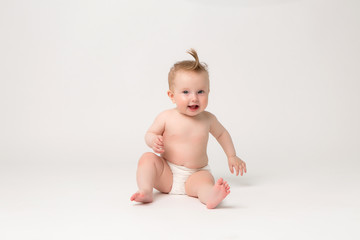 baby girl 6 months in diapers on white isolate background,6 months old baby girl, crawling happy...