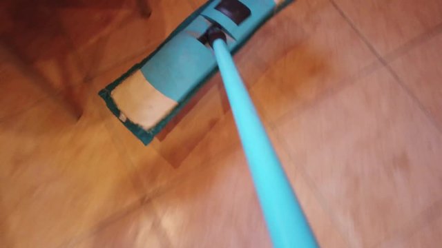 Young man with Mop, Cleaning Floor at Home. Man Sweeps Dust in room and brings Order and Cleanliness in House - Housework and Housekeeping concept.
