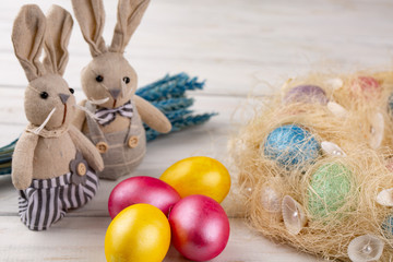 Toy bunny and colorful Easter eggs as a festive background composition