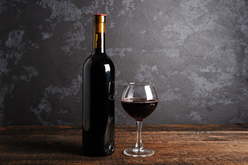 Red wine bottle on a wooden background