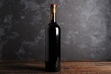 Red wine bottle on a wooden background
