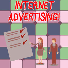 Word writing text Internet Advertising. Business photo showcasing uses the Internet to deliver promotional marketing Man and Woman in Business Suit Presenting Report of Check and Lines on Paper