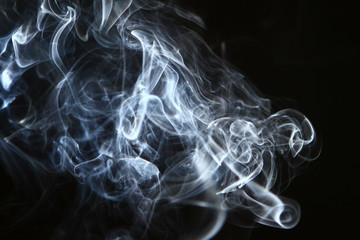 pretty flowing light blue smoke on the heavy black background.