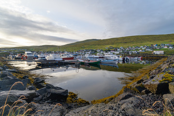 Fototapeta na wymiar Reflections at a small village port, Midvagur Faroe Islands