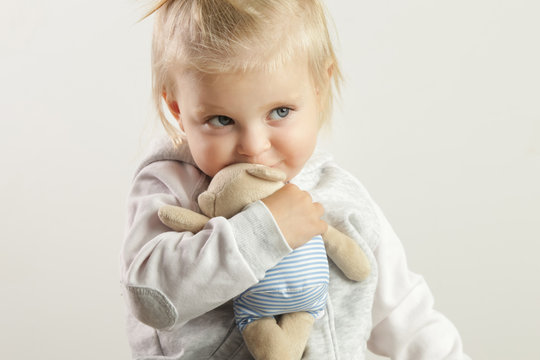 An adorable baby girl hugging with her favorite soft toy
