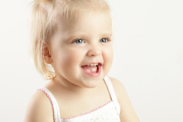 Studio portrait of adorable blonde smiling baby girl 