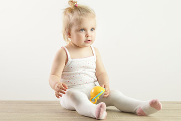 An adorable baby girl playing with a baby rattle toy