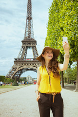happy modern solo traveller woman taking selfie with smartphone