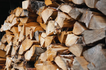 Dry chopped firewood of solid pine and birch wood in a pile.