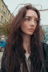 Thoughtful girl posing outdoors with windy hair