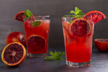 Blood orange cocktail with slices of citrus fruits and mint