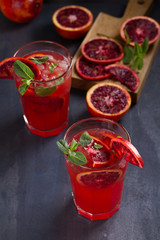 Blood orange cocktail with slices of citrus fruits and mint