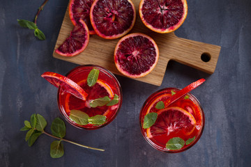 Blood orange cocktail with slices of citrus fruits and mint. View from above, top