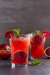 Blood orange cocktail with slices of citrus fruits and mint