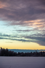 Fototapeta premium colorful sunset light over fields of snow in winter