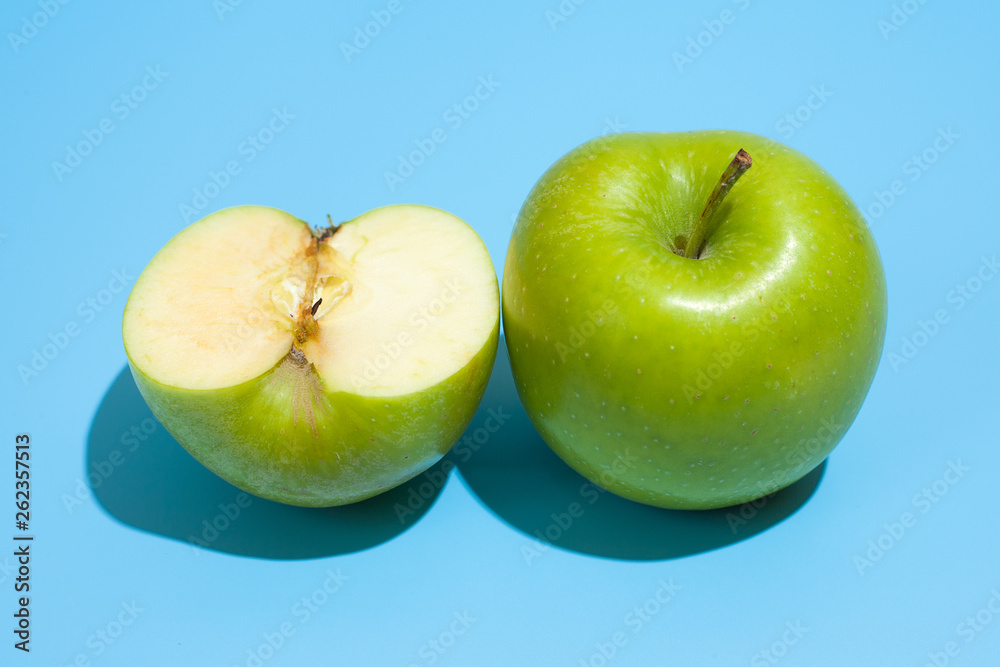 Wall mural Ripe parts green apple Isolated on a blue background. Healthy eating and dieting concept