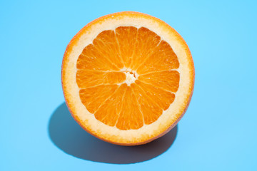 Ripe juicy delicious orange on blue background. Healthy eating and dieting concept