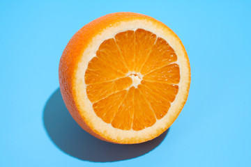 Ripe juicy delicious orange on blue background. Healthy eating and dieting concept