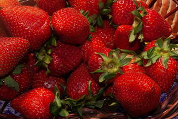 Strawberries with green leaves passion red color inside wicker basket or strips of wood natural and organic food in Mexico City with high nutritional content
