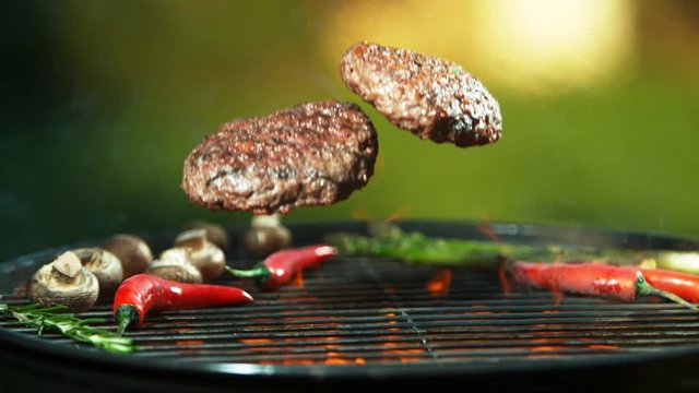 Super slow motion of falling hamburger steaks on grill. Filmed on high speed cinema camera, 1000 fps.