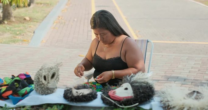 Indigenous woman of Kuna Indians from Dari&eacute;n or Darien province, Panama making traditional handicraft, object, tourist souvenir in Panama City. Native lady of Central American tribe sewing with beads