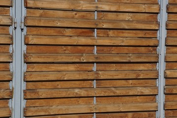 brown wooden texture of thin boards in the wall of the fence on the street