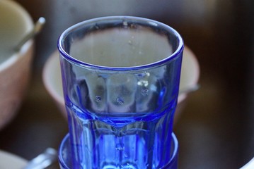 empty blue glass cup with water drops