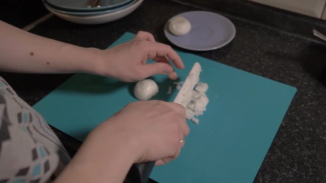 The girl cuts a bow with a knife on a blue cutting Board. Close up. Food video 4K