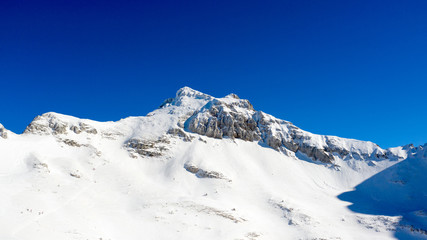 Winter landscape with the mountain peaks covered by heavy snow. Aerial view by drone. 