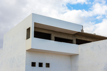 Part of a large white house against the sky