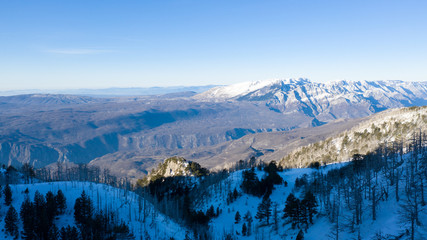 Winter landscape with the mountain peaks covered by heavy snow. Aerial view by drone. 