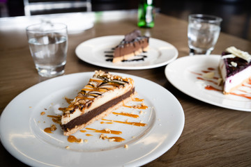 Close up on cake slices in plates on the table at the hotel restaurant