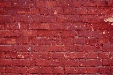 Old grungy brick wall. Free space for an inscription. Can be used as a background or poster. Fragment of a wall with bumps and peeling paint.