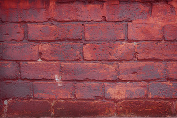 Old grungy brick wall. Free space for an inscription. Can be used as a background or poster. Fragment of a wall with bumps and peeling paint.