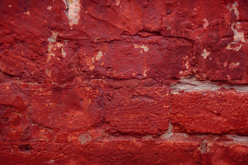 Old grungy brick wall. Free space for an inscription. Can be used as a background or poster. Fragment of a wall with bumps and peeling paint.