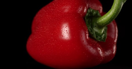 Sweet red bell pepper rotating on a black background with water drops. Shot on RED 6K camera in slow motion. - Powered by Adobe