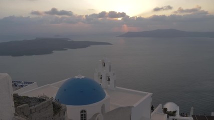Blue dome and belltower of St. Gerasimos church at sunset in Firostefani, Fira, Santorini, Greece, Europe - Powered by Adobe