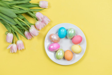 Colorful pearlescent Easter eggs and pink tulips